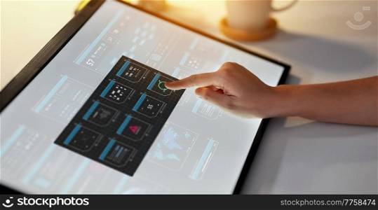 technology and people concept - hand working with virtual data on led light tablet or touch screen at night office. hand on led light tablet at night office
