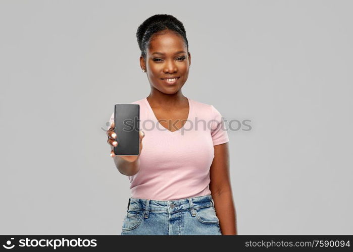 technology and people concept - happy african american woman using smartphone over grey background. happy african american woman using smartphone