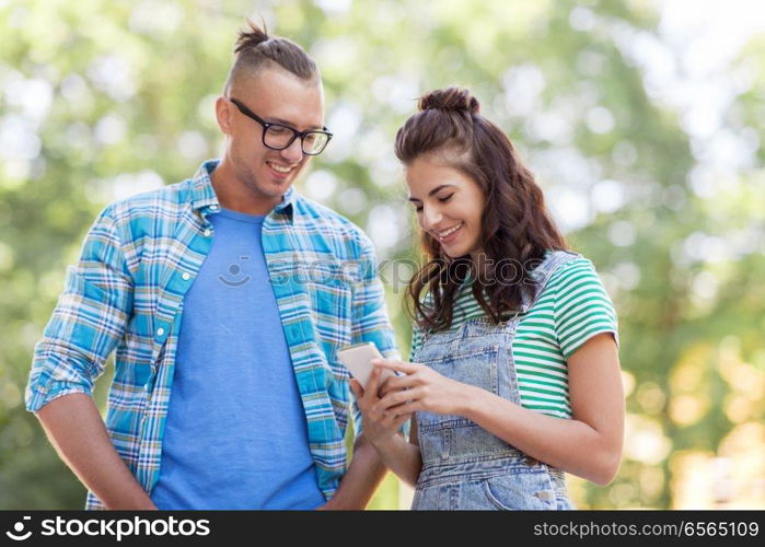 technology and people concept - happy couple with smartphone outdoors. happy couple with smartphone outdoors