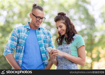 technology and people concept - happy couple with smartphone outdoors. happy couple with smartphone outdoors