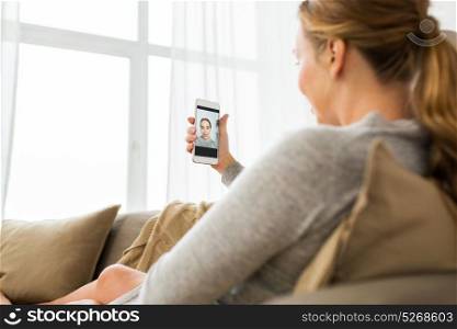 technology and people concept - happy woman with smartphone taking selfie at home. woman taking smartphone selfie at home