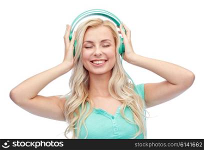 technology and people concept - happy young woman or teenage girl with headphones listening to music. happy young woman or teenage girl with headphones