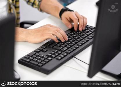 technology and people concept - male hands with red manicure typing on computer keyboard on table. male hands typing on computer keyboard on table