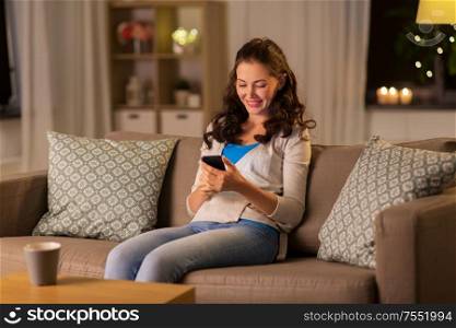 technology and people concept - smiling woman with smartphone at home. woman with smartphone at home