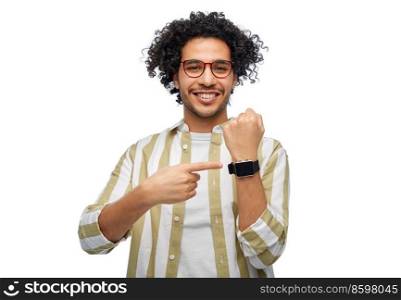 technology and people concept - smiling young man in glasses showing smart watch on his hand over white background. smiling young man in glasses showing smart watch