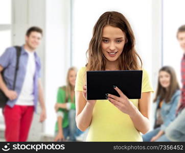 technology and people concept - teenage girl in blank yellow t-shirt using tablet computer over grey background. young woman or teenage girl using tablet computer