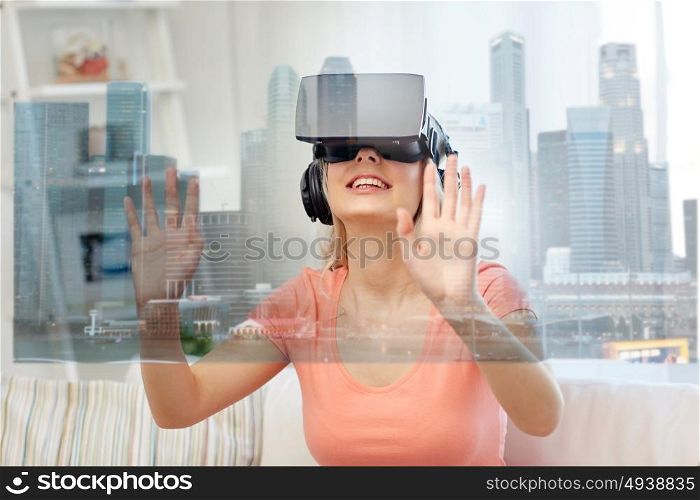 technology, augmented reality and entertainment concept - happy young woman in virtual headset 3d glasses and headphones playing game at home with singapore city skyscrapers on screen projection. woman in virtual reality headset with city