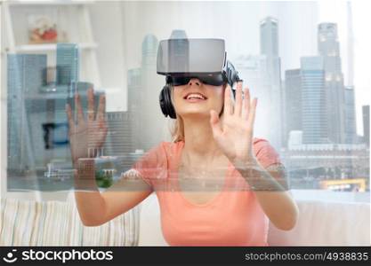 technology, augmented reality and entertainment concept - happy young woman in virtual headset 3d glasses and headphones playing game at home with singapore city skyscrapers on screen projection. woman in virtual reality headset with city