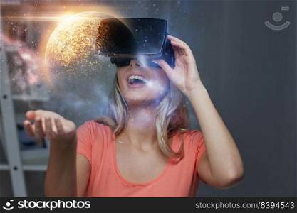 technology, augmented reality and people concept - happy young woman with virtual headset or 3d glasses over planet and space background. woman in virtual reality headset or 3d glasses
