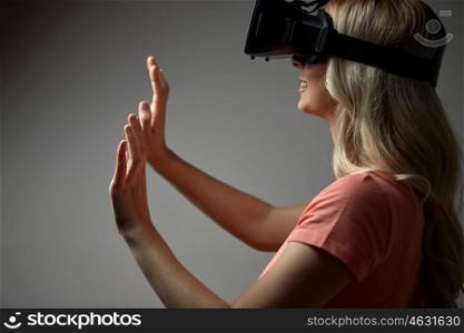 technology, augmented reality, entertainment and people concept - close up of happy young woman with virtual reality headset or 3d glasses touching something invisible
