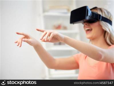 technology, augmented reality, entertainment and people concept - happy young woman with virtual reality headset or 3d glasses touching something invisible