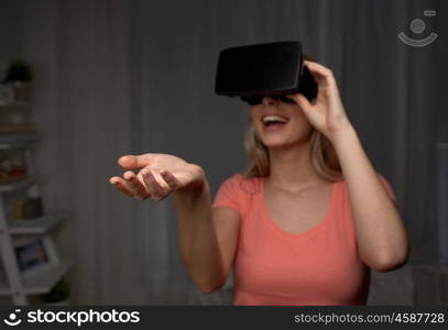 technology, augmented reality, entertainment and people concept - happy young woman with virtual reality headset or 3d glasses holding or catching something invisible