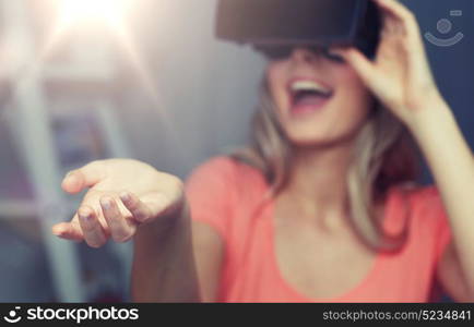 technology, augmented reality, entertainment and people concept - happy young woman with virtual reality headset or 3d glasses holding or catching something invisible. happy woman in virtual reality headset or glasses