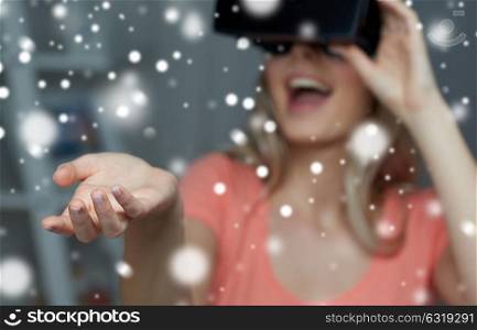 technology, augmented reality, entertainment and people concept - happy young woman with virtual headset or 3d glasses holding or catching something invisible. happy woman in virtual reality headset or glasses