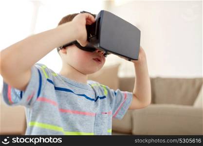 technology, augmented reality, entertainment and people concept - little boy with virtual headset or 3d glasses playing at home. little boy in vr headset or 3d glasses at home