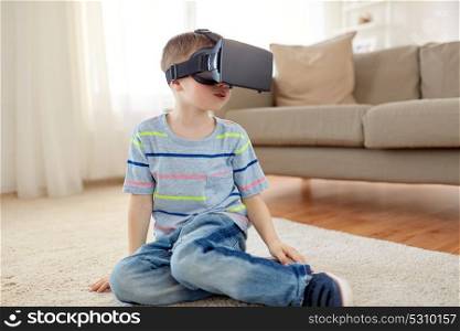 technology, augmented reality, entertainment and people concept - little boy with virtual headset or 3d glasses playing at home. little boy in vr headset or 3d glasses at home