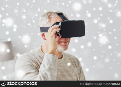 technology, augmented reality, entertainment and people concept - senior man with virtual headset or 3d glasses playing videogame at home over snow. old man in virtual reality headset or 3d glasses