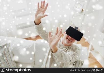 technology, augmented reality, entertainment and people concept - senior man with virtual headset or 3d glasses playing videogame at home over snow. old man in virtual reality headset or 3d glasses
