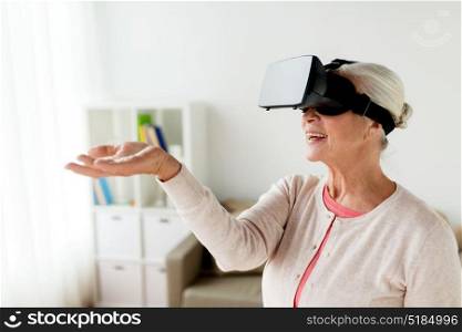 technology, augmented reality, entertainment and people concept - senior woman with virtual headset or 3d glasses playing videogame at home. old woman in virtual reality headset or 3d glasses