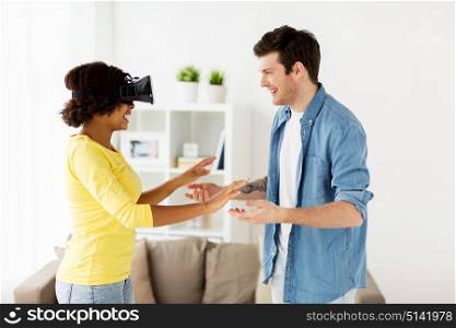 technology, augmented reality, gaming, entertainment and people concept - happy couple with virtual headset or 3d glasses playing at home. happy couple with virtual reality headset at home