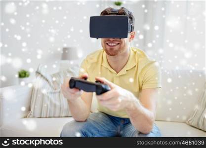 technology, augmented reality, gaming, entertainment and people concept - happy young man with virtual headset or 3d glasses playing video game with controller gamepad at home over snow