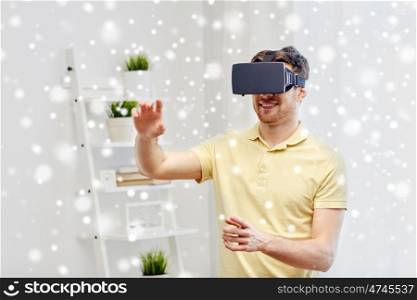 technology, augmented reality, gaming, entertainment and people concept - happy young man with virtual headset or 3d glasses playing video game at home over snow