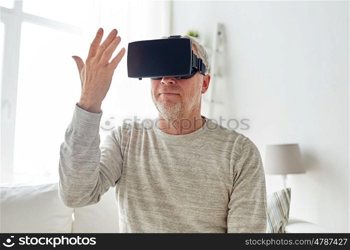 technology, augmented reality, gaming, entertainment and people concept - senior man with virtual headset or 3d glasses playing videogame and looking at his hand at home