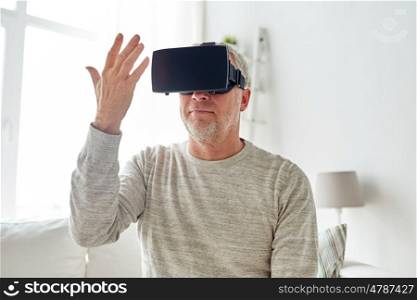 technology, augmented reality, gaming, entertainment and people concept - senior man with virtual headset or 3d glasses playing videogame and looking at his hand at home