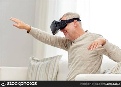 technology, augmented reality, gaming, entertainment and people concept - senior man with virtual headset or 3d glasses playing videogame at home