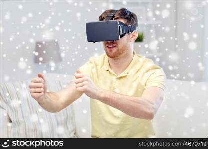 technology, augmented reality, gaming, entertainment and people concept - young man with virtual headset or 3d glasses playing racing videogame at home over snow