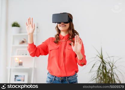 technology, augmented reality, gaming, entertainment and people concept - young man with virtual headset or 3d glasses playing videogame at home. happy woman in virtual reality headset at home