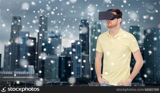 technology, augmented reality, travel, entertainment and people concept - young man with virtual headset or 3d glasses over singapore city skyscrapers background over snow
