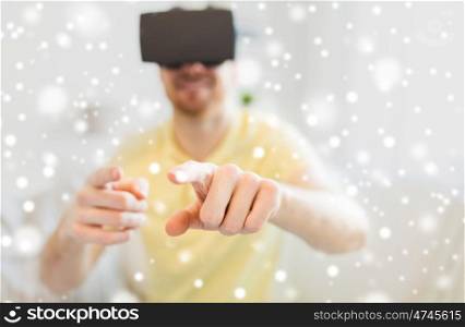 technology, augmented reality, winter, christmas and people concept - close up of happy young man with virtual headset or 3d glasses playing game at home over snow