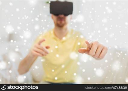 technology, augmented reality, winter, christmas and people concept - close up of happy young man with virtual headset or 3d glasses playing game at home over snow