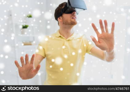 technology, augmented reality, winter, christmas and people concept - close up of happy young man with virtual headset or 3d glasses playing videogame at home over snow