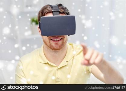 technology, augmented reality, winter, christmas and people concept - happy young man with virtual headset or 3d glasses playing video game over snow