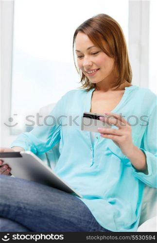 technology, banking, money, internet and home concept - smiling woman with tablet pc computer and credit card at home