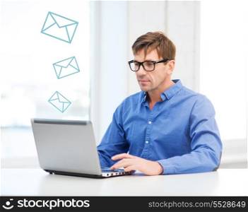 technology, business and communication concept - man in eyeglasses working with laptop at home