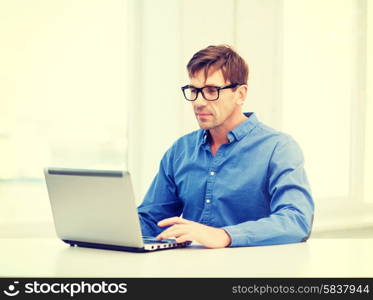 technology, business and lifestyle concept - man in eyeglasses working with laptop at home