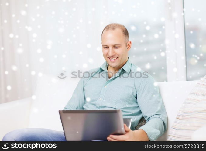 technology, business and lifestyle concept - smiling man working with laptop at home