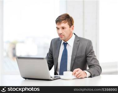 technology, business and office concept - handsome businessman working with laptop computer