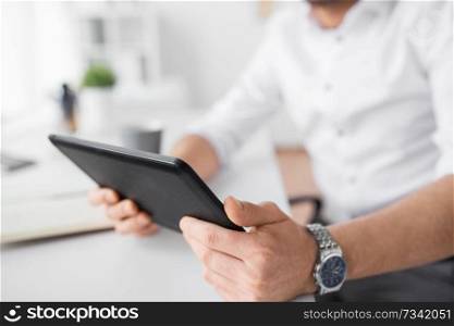 technology, business and people concept - close up of businessman with tablet pc at office. close up of businessman with tablet pc at office