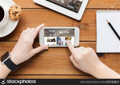 technology, business, communication, people and advertisement concept - close up of woman with blank smartphone screen and coffee cup on wooden table