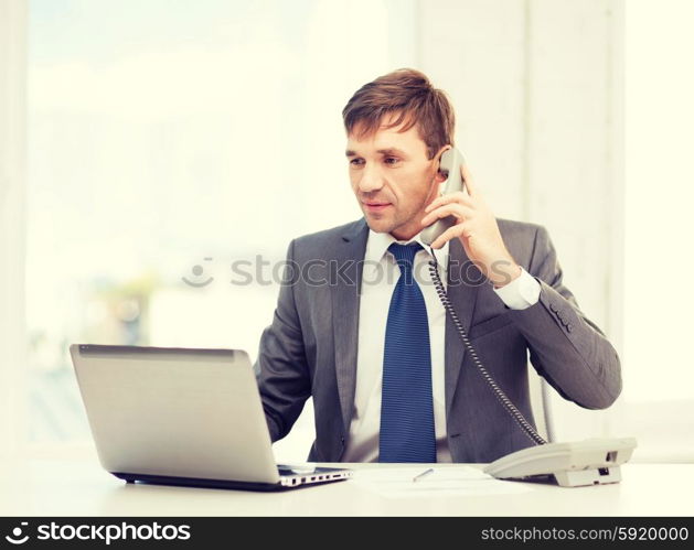 technology, business, education and office concept - handsome businessman working with laptop computer, phone and documents