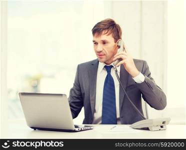 technology, business, education and office concept - handsome businessman working with laptop computer, phone and documents