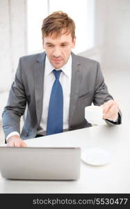 technology, business, internet and office concept - handsome businessman working with laptop computer