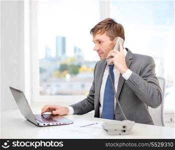 technology, business, internet and office concept - handsome businessman working with laptop computer, phone and documents