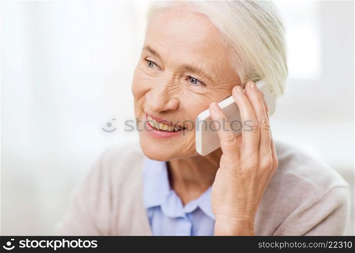 technology, communication age and people concept - happy senior woman with smartphone calling at home