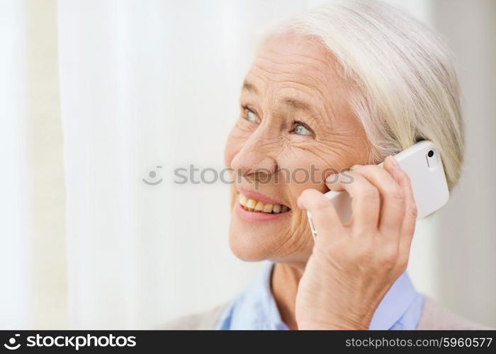 technology, communication age and people concept - happy senior woman with smartphone calling at home