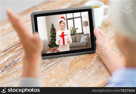 technology, communication and christmas holidays concept - grandmother having video call with her grandson on tablet computer at home. grandmother has video call with boy on christmas